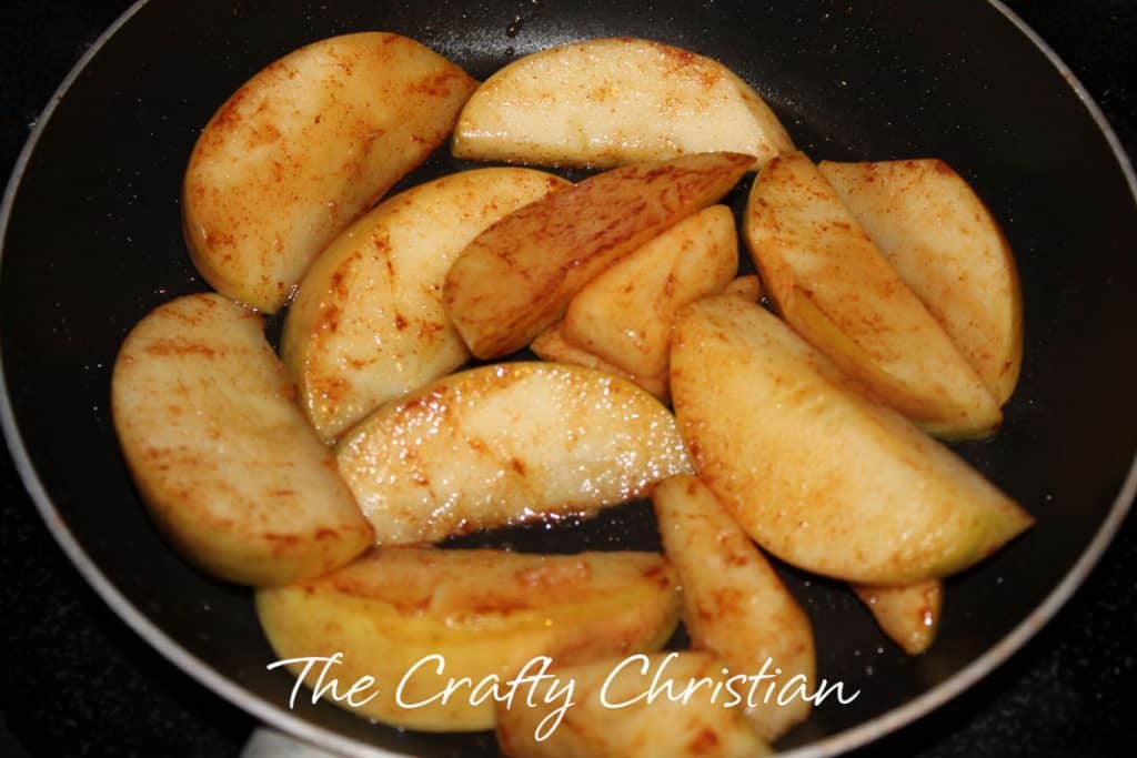 apple slices with cinnamon cooking in a pan