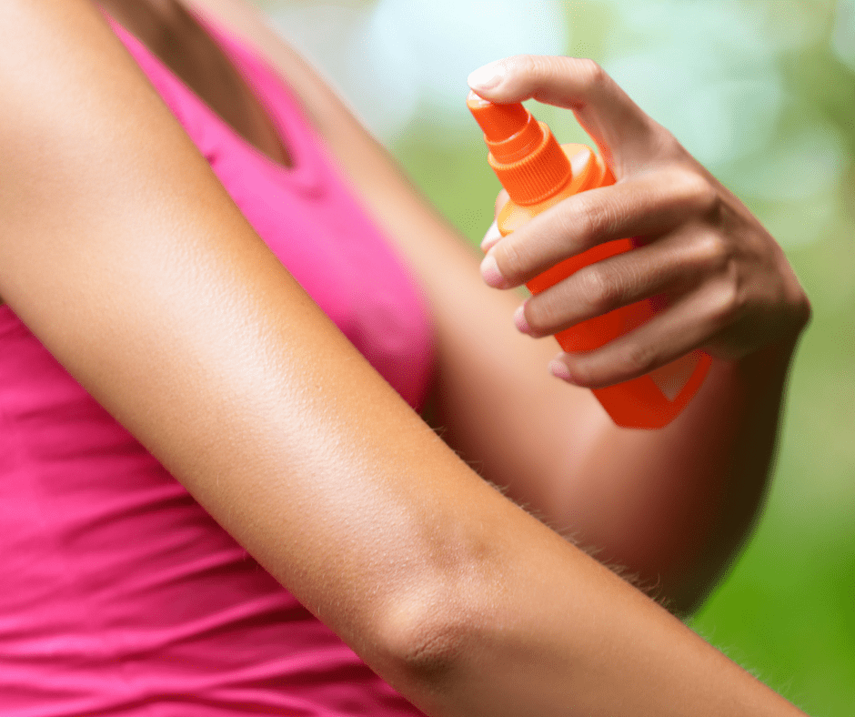 woman spraying homemade bug spray on her arm