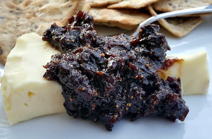 fig jam over brie with crackers in the background