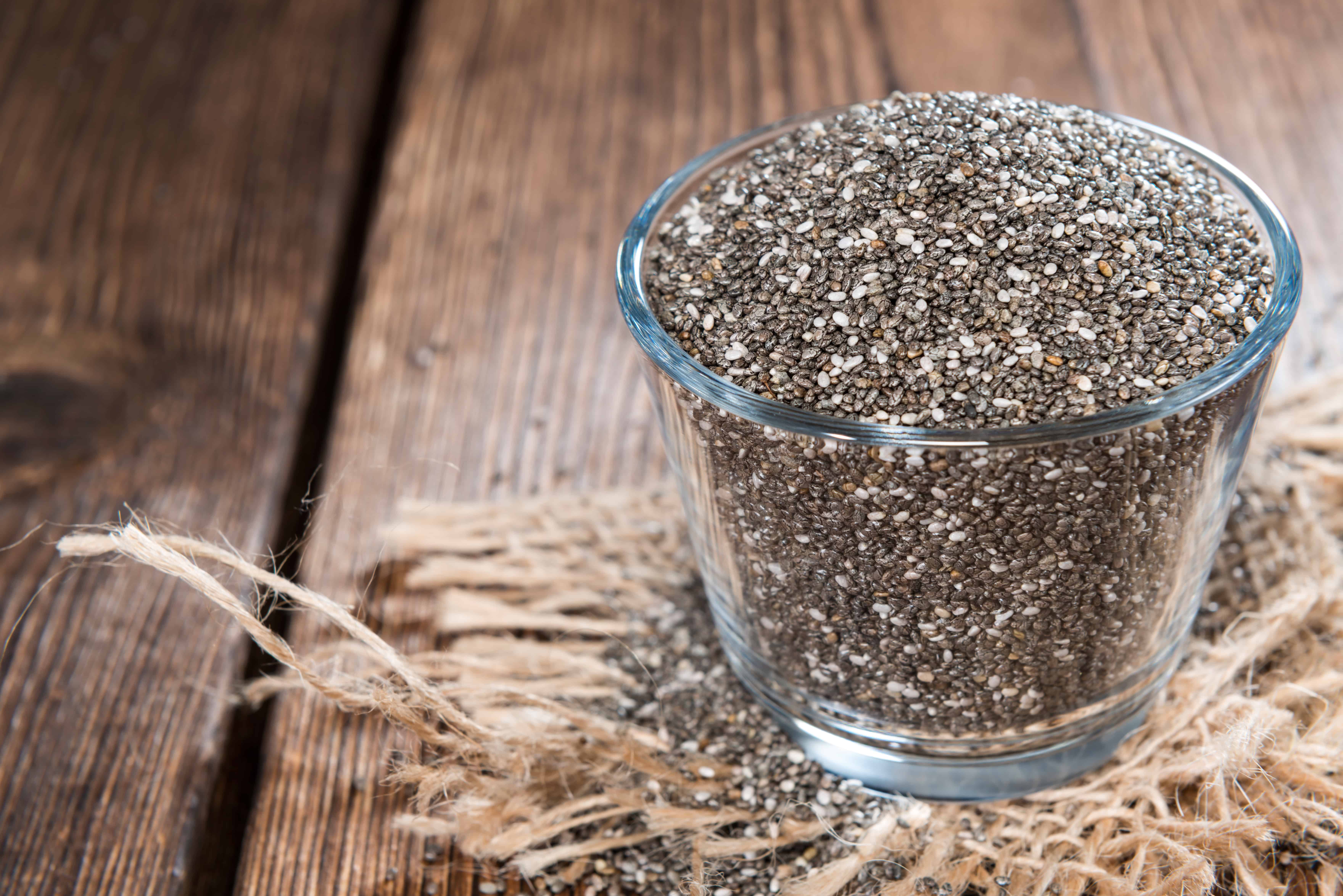 glass bowl of chia seeds on a wooden table