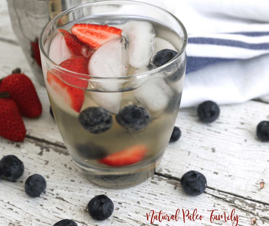 patriotic paleo margarita with silver shaker cup, strawberries, and blueberries