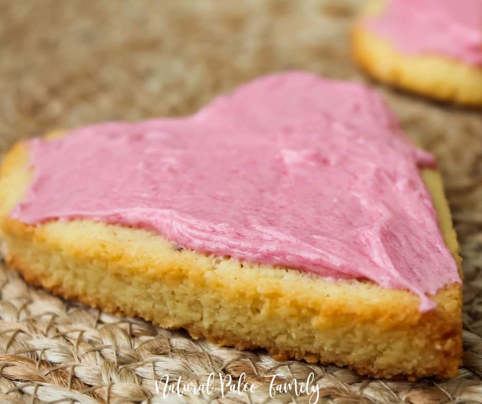 close-up of a heart shaped, pink frosted paleo valentine's day cookie