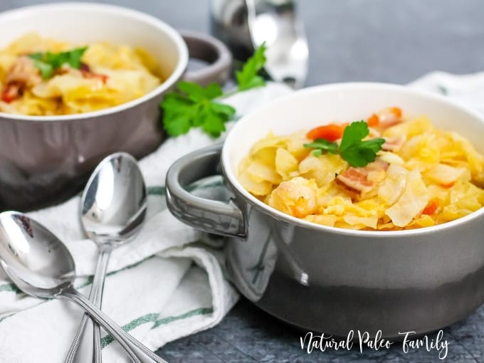 two bowls of cabbage bacon soup on white napkin